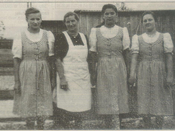 Osteuropäische Zwangsarbeiterinnen (gleiches Kleid) mit einer Bäuerin.